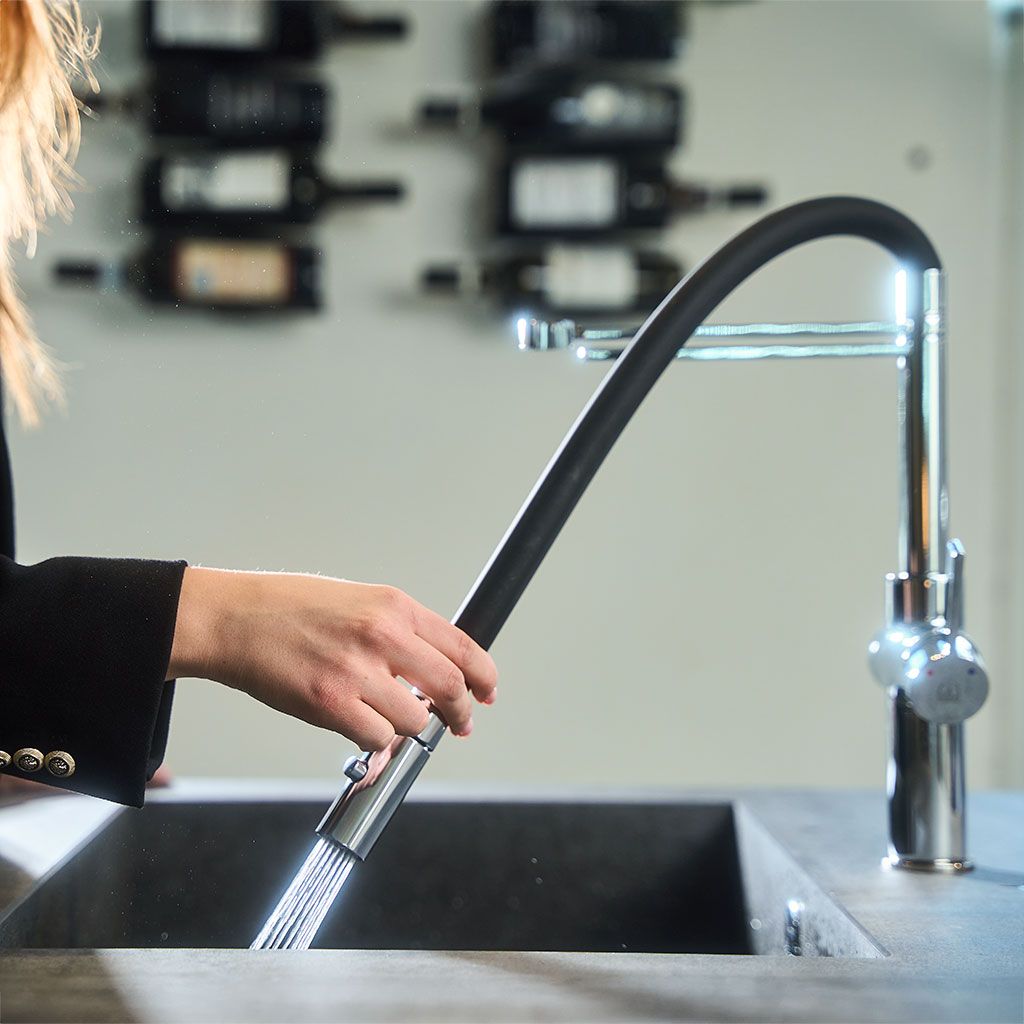 Hand löst den schwarzen Flex-Schlauch der Levanto Neo als Brause und spült in die Spüle
